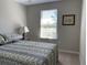 Cozy bedroom with a patterned bedspread, side table and large window providing natural light at 1013 Flowing Tide Dr, Orlando, FL 32828