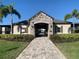 Elegant community clubhouse entrance with stone accents, arched entryway, and palm tree landscaping at 1013 Flowing Tide Dr, Orlando, FL 32828