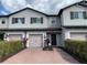 Charming townhome exterior with a brick driveway, one-car garage, and manicured landscaping at 1013 Flowing Tide Dr, Orlando, FL 32828