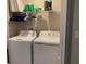 Neat laundry area with a full-size washer and dryer, plus storage shelves for supplies at 1013 Flowing Tide Dr, Orlando, FL 32828