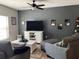 Cozy living room featuring gray walls, neutral furniture, ceiling fan and a TV on a white cabinet at 1013 Flowing Tide Dr, Orlando, FL 32828