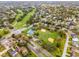 An aerial view shows a residential neighborhood with a park featuring baseball fields and tennis courts at 112 E Cumberland Cir, Longwood, FL 32779