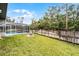 Large, grassy backyard featuring a fence and view of a screened-in pool, ideal for outdoor activities and privacy at 112 E Cumberland Cir, Longwood, FL 32779