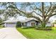 Charming single-story home with a well-maintained lawn, mature tree, and an attached two-car garage at 112 E Cumberland Cir, Longwood, FL 32779