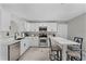 Contemporary kitchen with stainless steel appliances, white cabinetry, and a breakfast bar, ideal for casual dining at 112 E Cumberland Cir, Longwood, FL 32779