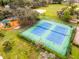 Aerial view of tennis courts next to a playground in a leafy community at 112 E Cumberland Cir, Longwood, FL 32779