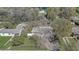 An aerial view of a single-story home surrounded by mature trees and lush greenery in a neighborhood at 1129 Ne 12Th St, Ocala, FL 34470