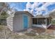 Charming exterior featuring blue door, screened porch, and gray siding provides a cozy curb appeal at 1129 Ne 12Th St, Ocala, FL 34470