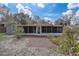 Exterior view of home featuring a screened-in porch and rear yard at 1129 Ne 12Th St, Ocala, FL 34470