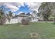 Single-story home with a lush green lawn, white picket fence, and a detached garage at 1129 Ne 12Th St, Ocala, FL 34470