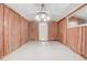 This garage area features wood paneled walls, a white ceiling, and a door to the outside at 1129 Ne 12Th St, Ocala, FL 34470