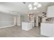 Open-concept living space with a kitchen island, stainless steel appliances, and white cabinets at 1129 Ne 12Th St, Ocala, FL 34470