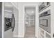 Pantry with white shelving next to the stainless steel refrigerator and wall oven at 1129 Ne 12Th St, Ocala, FL 34470