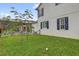 Backyard view showing the screened lanai next to the home, with lush green grass at 11402 Camden Loop Way, Windermere, FL 34786