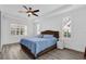 This bedroom features wood-look floors, natural light from large windows, and a ceiling fan at 11402 Camden Loop Way, Windermere, FL 34786