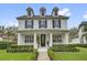 Stunning two-story home with a welcoming front porch, blue shutters, and professionally landscaped yard at 11402 Camden Loop Way, Windermere, FL 34786