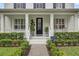 Inviting front porch with decorative plants, a brick walkway, and a stylish glass-paneled front door at 11402 Camden Loop Way, Windermere, FL 34786