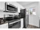 Compact kitchen with stainless steel appliances, granite countertops, and a bright window at 11402 Camden Loop Way, Windermere, FL 34786