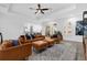 Spacious living room featuring leather furniture, a ceiling fan, and an open layout to the kitchen at 11402 Camden Loop Way, Windermere, FL 34786