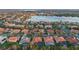 Aerial view of a suburban neighborhood with lush trees, bodies of water, and tiled roofs at 11733 Delwick Dr, Windermere, FL 34786