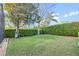 Expansive backyard featuring lush green grass, mature landscaping, and a well-maintained privacy hedge at 11733 Delwick Dr, Windermere, FL 34786