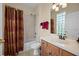 Standard bathroom with a shower-tub combination, single sink vanity, and neutral shower curtain at 11733 Delwick Dr, Windermere, FL 34786