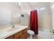 Standard bathroom with a shower-tub combination, single sink vanity, and a red shower curtain at 11733 Delwick Dr, Windermere, FL 34786