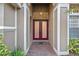 Welcoming entryway featuring double doors, neutral tile flooring, arched doorway, and high ceilings with a decorative light fixture at 11733 Delwick Dr, Windermere, FL 34786