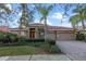 Charming single-story home with well-manicured lawn, mature landscaping, and a brick paved driveway leading to a two car garage at 11733 Delwick Dr, Windermere, FL 34786