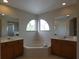 Bright bathroom with a garden tub nestled between dual sinks and large mirrors at 1230 Elegance Ct, Orlando, FL 32828