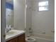 Bright bathroom featuring a single sink vanity, mirror, and tub with tiled shower, providing a clean and functional space at 1230 Elegance Ct, Orlando, FL 32828