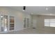 Open living space with tile flooring, French doors, a white door, and an adjacent kitchen at 1230 Elegance Ct, Orlando, FL 32828