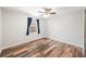 This bedroom features beautiful wood floors, a ceiling fan, and a window with blue curtains at 1317 Independence Ln, Mount Dora, FL 32757