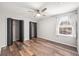 Bright bedroom with wood floors, ceiling fan, large closets and bright window with white curtain at 1317 Independence Ln, Mount Dora, FL 32757