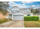 Charming two-story home featuring a gray exterior, two-car garage, and manicured lawn at 1317 Independence Ln, Mount Dora, FL 32757