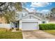 Charming two-story home featuring a gray exterior, two-car garage, and manicured lawn at 1317 Independence Ln, Mount Dora, FL 32757