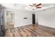 A spacious main bedroom shows off an ensuite bath, ceiling fan, and wood-look floors at 1317 Independence Ln, Mount Dora, FL 32757