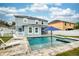 Backyard pool and spa with umbrella and lounge chairs, enclosed by a white picket fence at 1317 Independence Ln, Mount Dora, FL 32757