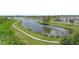 Aerial shot of a neighborhood lake showcasing the walking path and surrounding green spaces at 1714 Leatherback Ln, St Cloud, FL 34771