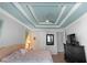 Charming main bedroom featuring decorative tray ceiling, ceiling fan, and wood-look flooring at 1714 Leatherback Ln, St Cloud, FL 34771