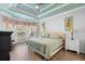 Bright main bedroom showcasing tray ceiling, wood floors, and a comfortable, well-lit space at 1714 Leatherback Ln, St Cloud, FL 34771