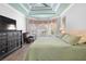 Serene main bedroom with tray ceiling, large windows, and a comfortable seating area at 1714 Leatherback Ln, St Cloud, FL 34771