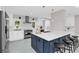 Bright kitchen with white cabinets, a dark island with seating, and stainless-steel appliances at 2015 Summerfield Rd, Winter Park, FL 32792