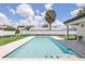 Sparkling pool with travertine tile, surrounded by lush lawn and a privacy fence for secluded outdoor enjoyment at 2015 Summerfield Rd, Winter Park, FL 32792