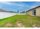 Green backyard with a privacy fence and a sliding glass door, perfect for outdoor enjoyment and relaxation at 212 Fig Ct, Poinciana, FL 34759