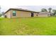 Exterior backyard view showcasing green lawn and the side of the house at 212 Fig Ct, Poinciana, FL 34759