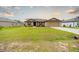 Inviting single-story home features a manicured lawn enhancing its curb appeal with neutral tones at 212 Fig Ct, Poinciana, FL 34759