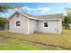 View of a gray home's backyard with a chain fence, window, and partial view of the roof at 230 Hennis Rd, Winter Garden, FL 34787