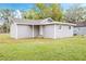 Exterior view of the rear of the home featuring a bright, grassy backyard and neutral paint at 230 Hennis Rd, Winter Garden, FL 34787