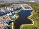 Stunning aerial view of a community with a lake, pool, and modern apartment buildings surrounded by lush greenery at 2331 Celebration Blvd, Celebration, FL 34747